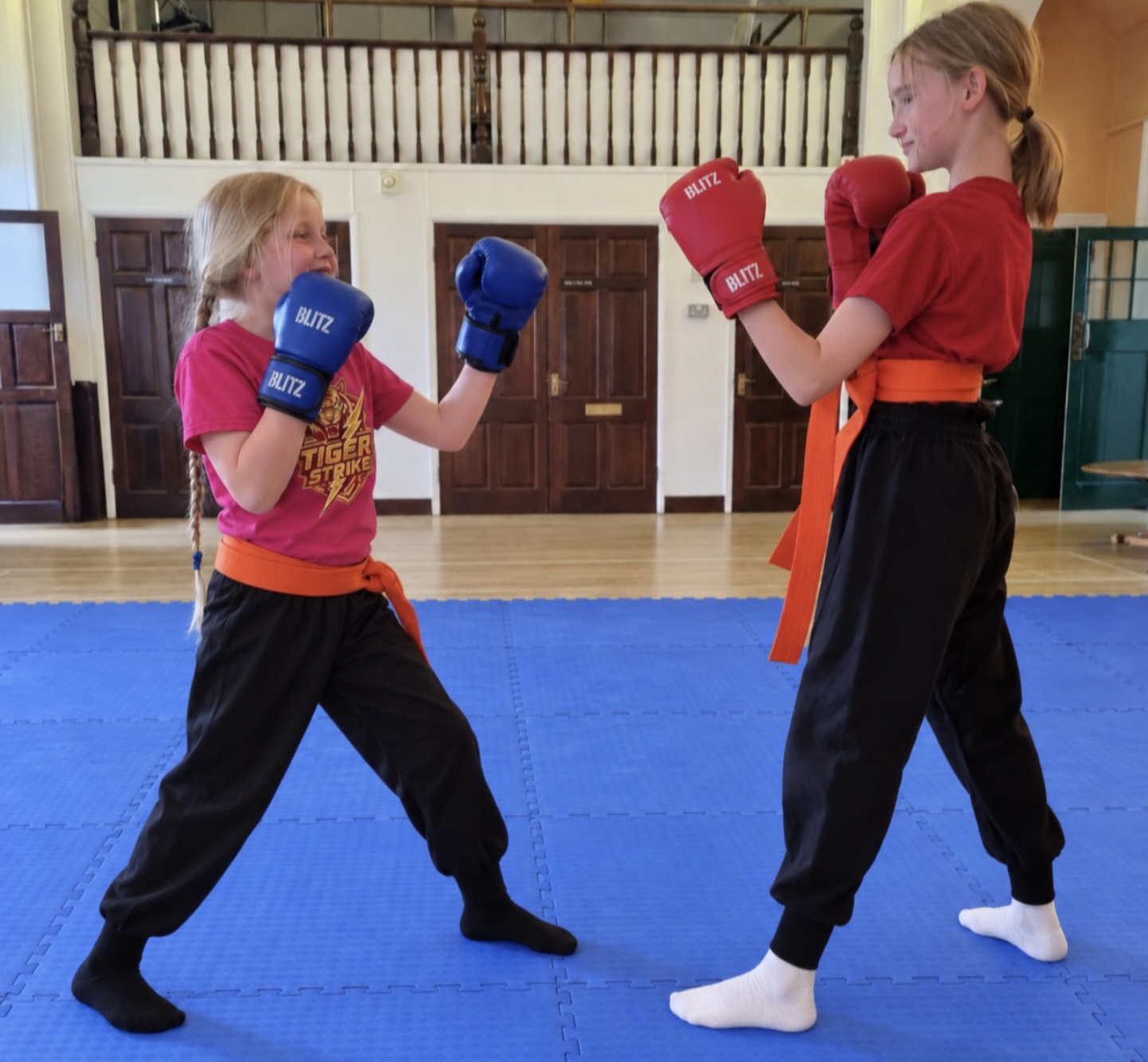 Two Tiger Strike students practising with boxing gloves