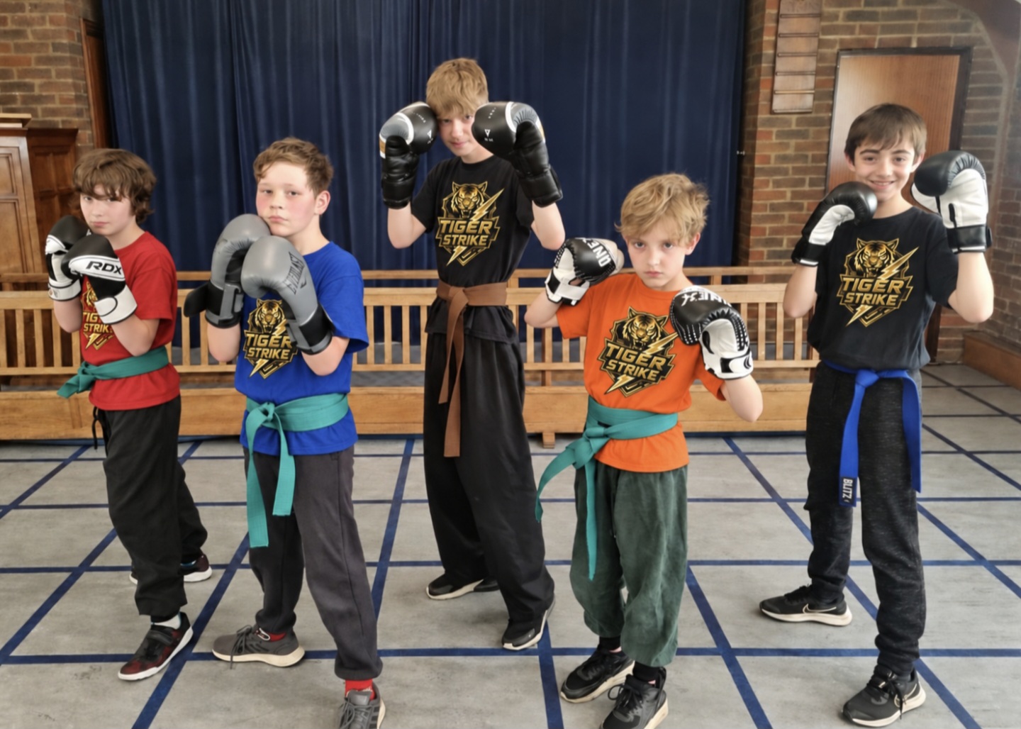 Five Tiger Strike students posing in training gear
