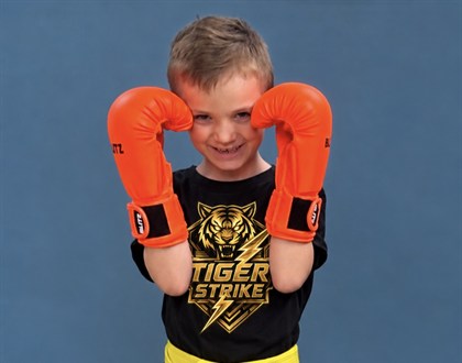 Young Tiger Strike student wearing orange training gloves